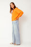 lauren-cardigan-gebreid-oranje-knoopsluiting-ribversieringen-sweet-like-you-model-zijaanzicht-2