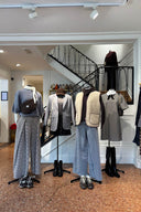 Herfst- en wintercollectie etalage bij Sienna met vier etalagepoppen gehuld in geruite broeken en jurken, een grijze blazer, teddy bodywarmer, jeans en zwarte laarzen.
